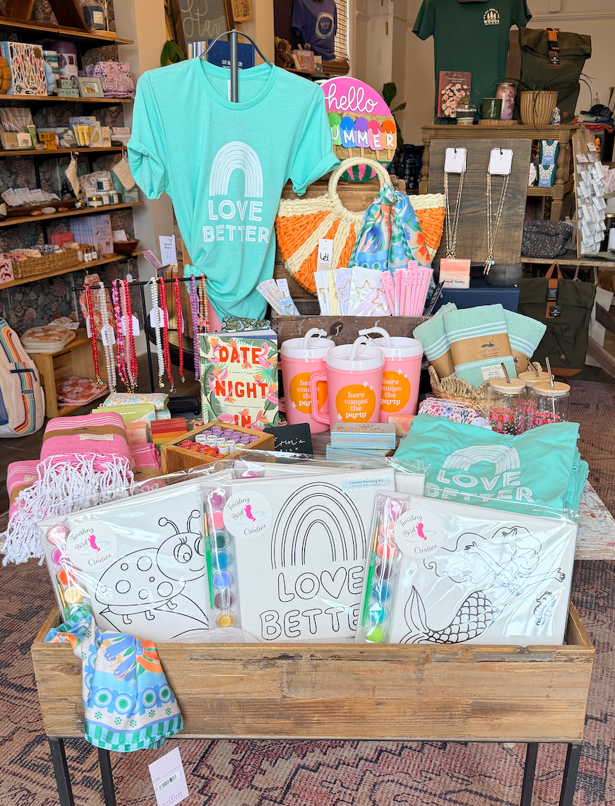 Display of merchandise including t-shirts and coloring books in a store setting.
